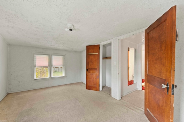 unfurnished bedroom featuring light carpet and a textured ceiling