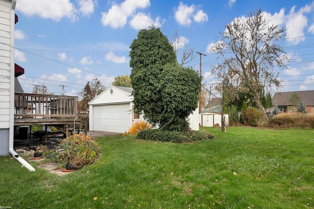 view of yard with a garage, a wooden deck, and a storage shed