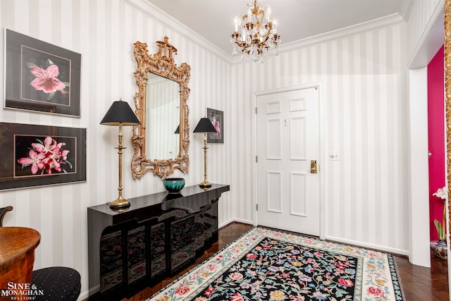 entrance foyer with dark hardwood / wood-style floors, an inviting chandelier, and ornamental molding