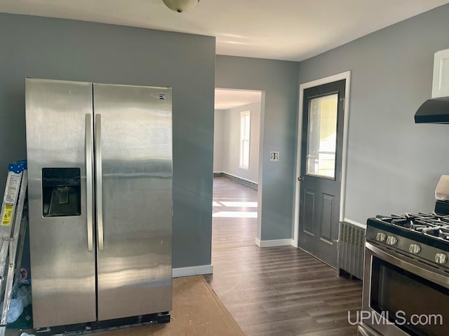 kitchen with hardwood / wood-style floors, stainless steel appliances, radiator heating unit, and range hood