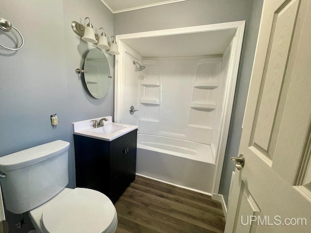 full bathroom featuring hardwood / wood-style flooring, bathing tub / shower combination, vanity, crown molding, and toilet