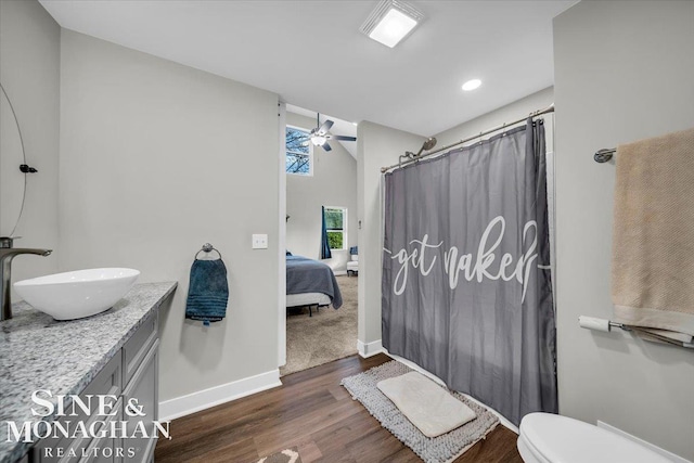 bathroom with vanity, hardwood / wood-style floors, curtained shower, toilet, and ceiling fan