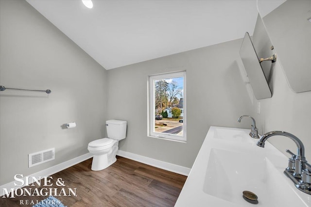 bathroom featuring toilet, lofted ceiling, sink, and wood-type flooring