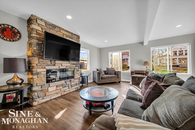 living room featuring a fireplace, wood-type flooring, and beam ceiling