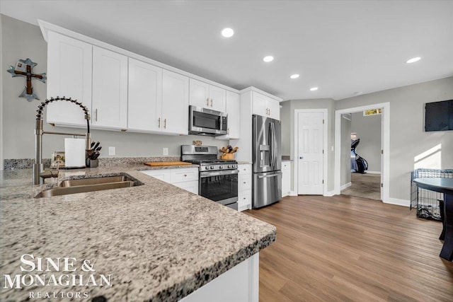 kitchen featuring white cabinets, hardwood / wood-style floors, stainless steel appliances, and sink