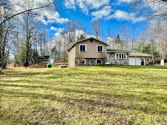 rear view of house with a lawn and a storage shed