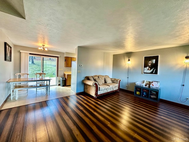 unfurnished living room featuring wood-type flooring, a textured ceiling, and a chandelier