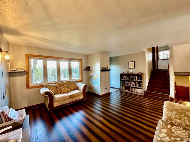 living room featuring a textured ceiling and dark hardwood / wood-style floors