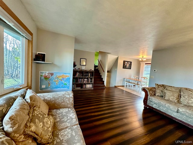 living room with dark hardwood / wood-style flooring and a textured ceiling