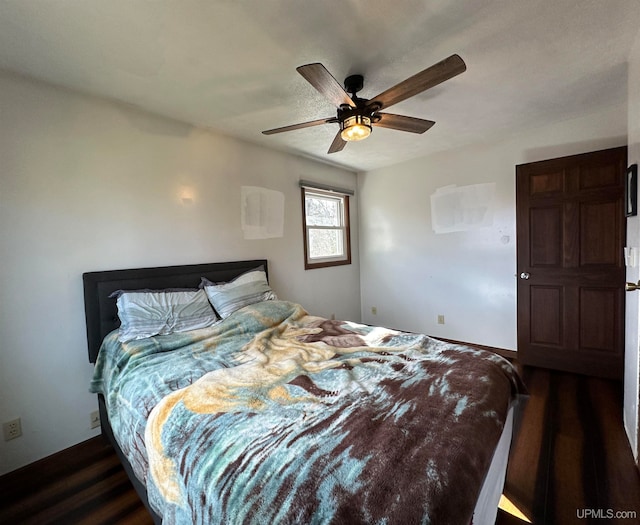 bedroom with dark hardwood / wood-style flooring and ceiling fan