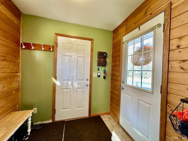 entryway featuring light tile patterned floors and wooden walls