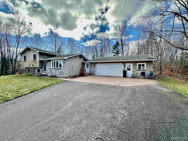 tri-level home with a garage and a front lawn