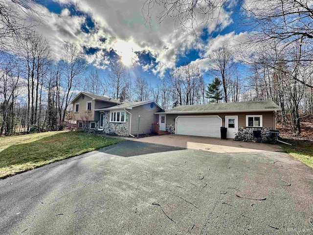 tri-level home featuring a front yard and a garage