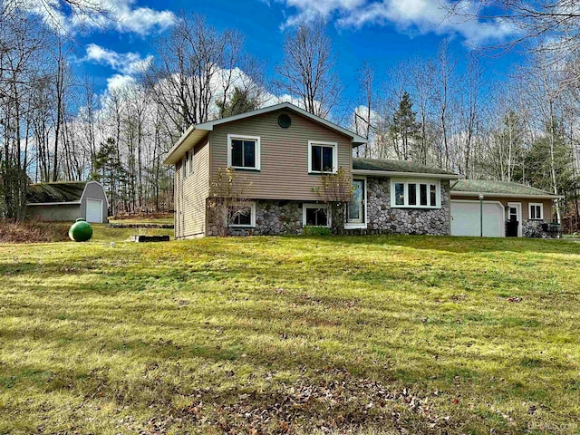 view of front of property with a front lawn, a garage, and a storage unit