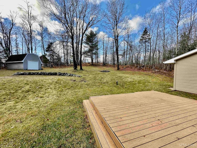 view of yard with a wooden deck, an outbuilding, and a garage