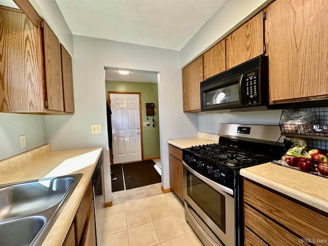 kitchen featuring light tile patterned floors, stainless steel appliances, and sink