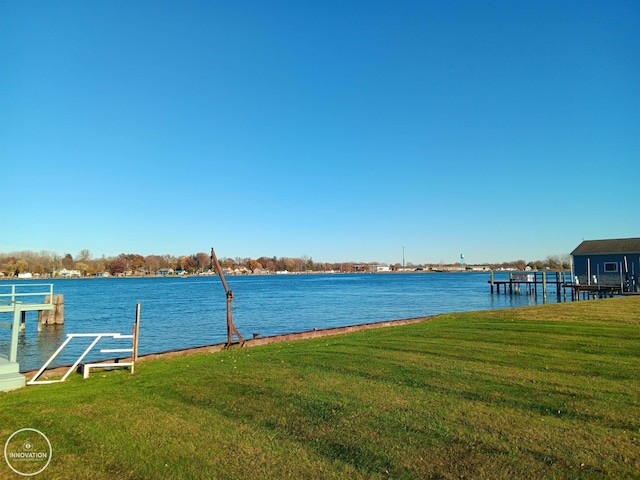 view of dock with a water view and a yard