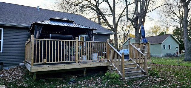 rear view of house with a gazebo and a deck