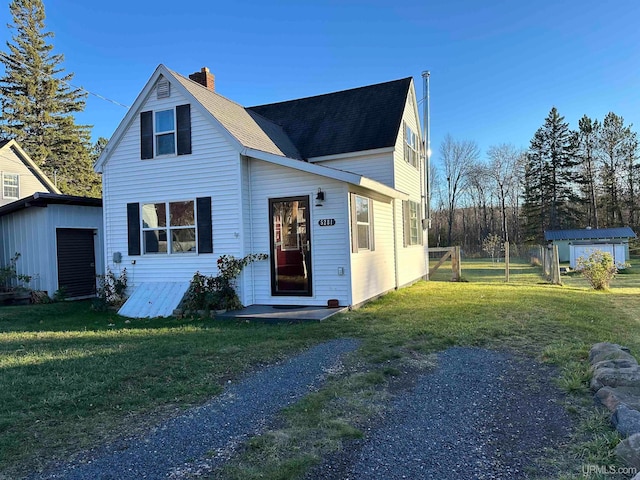 view of front of property with a front yard and a storage unit