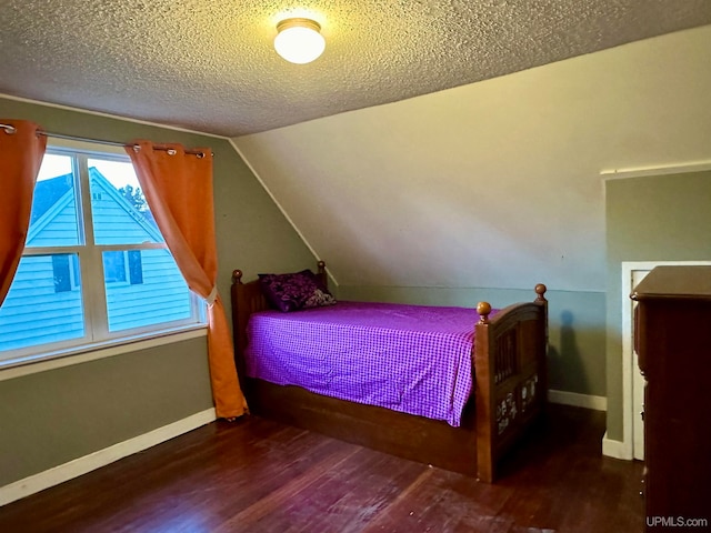 bedroom featuring dark hardwood / wood-style floors, a textured ceiling, and vaulted ceiling