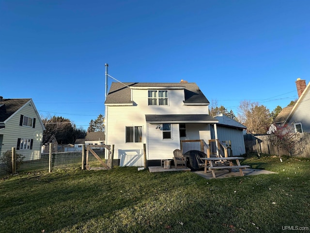 rear view of property featuring a lawn and a patio