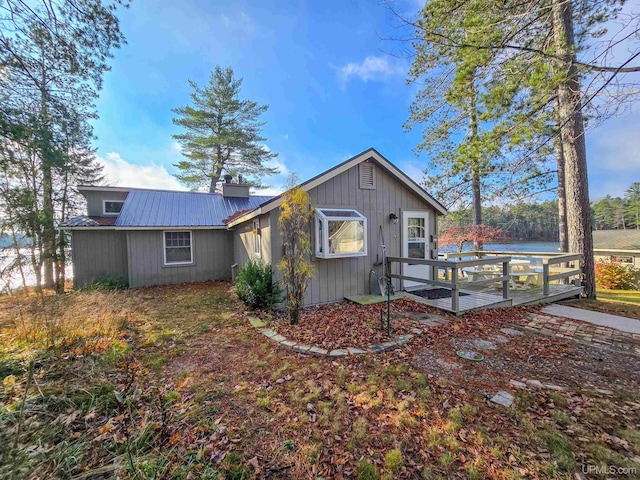 exterior space with a deck, metal roof, and a chimney