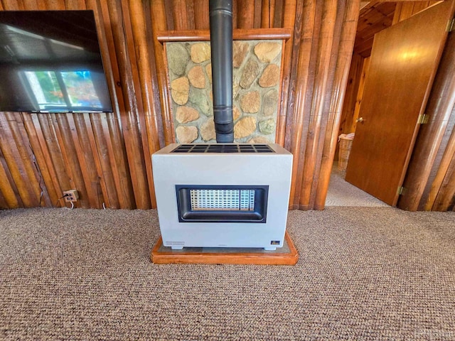 details with carpet flooring, heating unit, a wood stove, and wooden walls