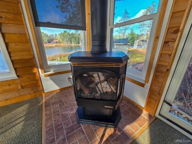 interior details with a water view, a wood stove, and baseboards