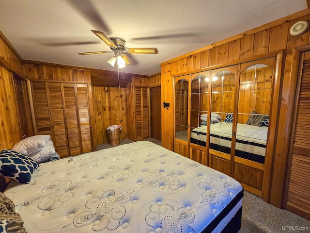 bedroom featuring carpet floors, wooden walls, and a ceiling fan