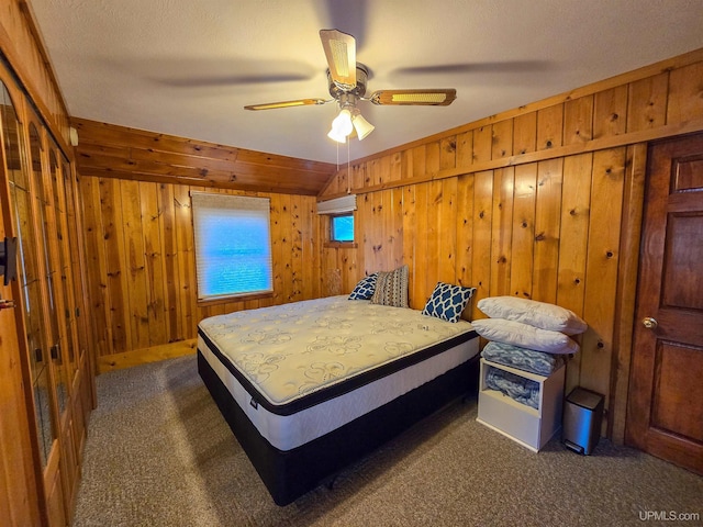 carpeted bedroom featuring wood walls and ceiling fan