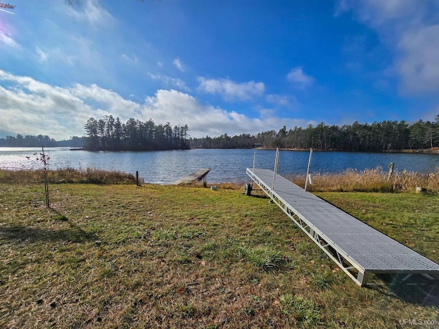 view of dock featuring a water view and a yard