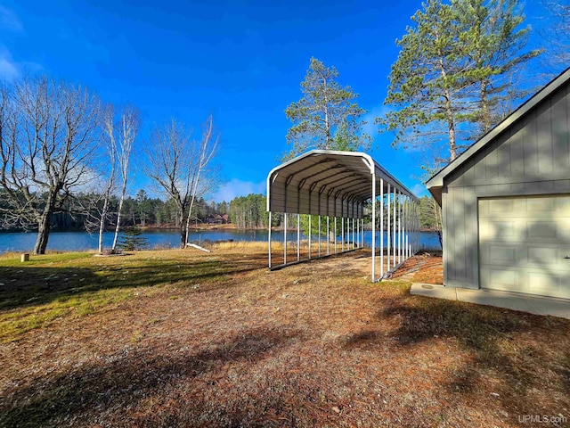 view of yard featuring a water view and a detached carport