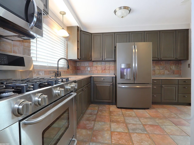 kitchen with sink, decorative light fixtures, decorative backsplash, and stainless steel appliances