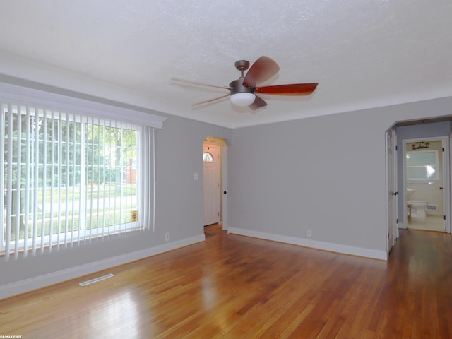 unfurnished room featuring a textured ceiling, hardwood / wood-style flooring, and ceiling fan