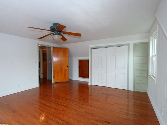 unfurnished bedroom with hardwood / wood-style flooring, ceiling fan, and a closet