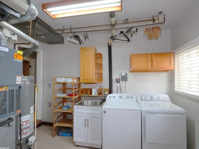 laundry area featuring heating unit, cabinets, sink, and separate washer and dryer