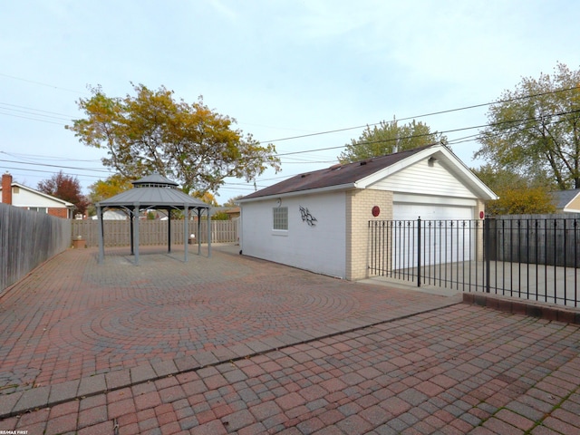 exterior space featuring a garage, an outdoor structure, and a gazebo