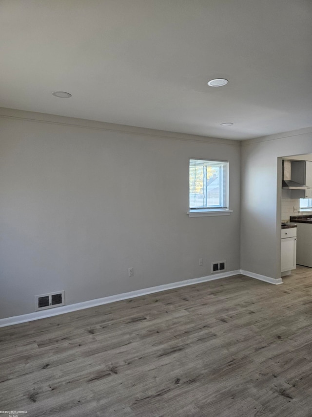 empty room featuring ornamental molding and light hardwood / wood-style flooring