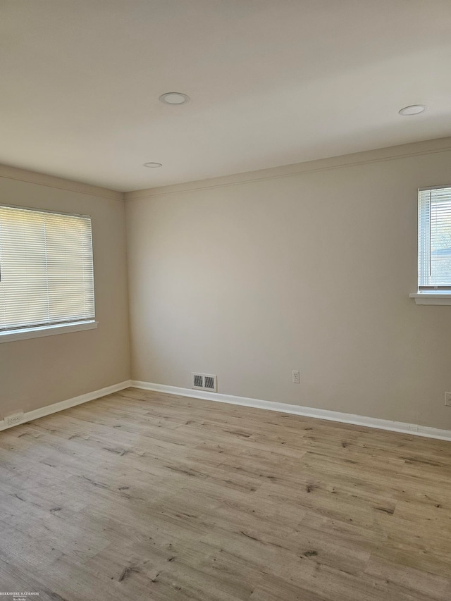 unfurnished room featuring light wood-type flooring and ornamental molding