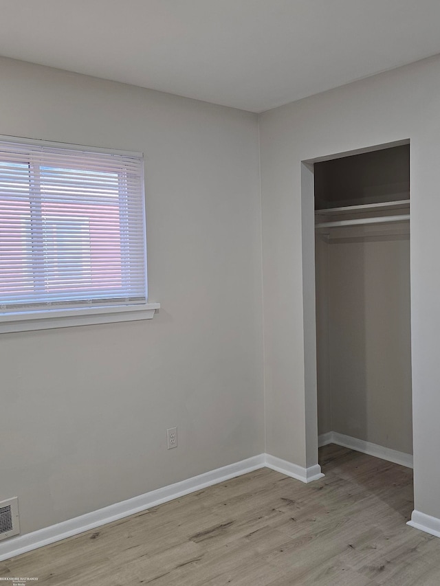 unfurnished bedroom featuring light wood-type flooring and a closet