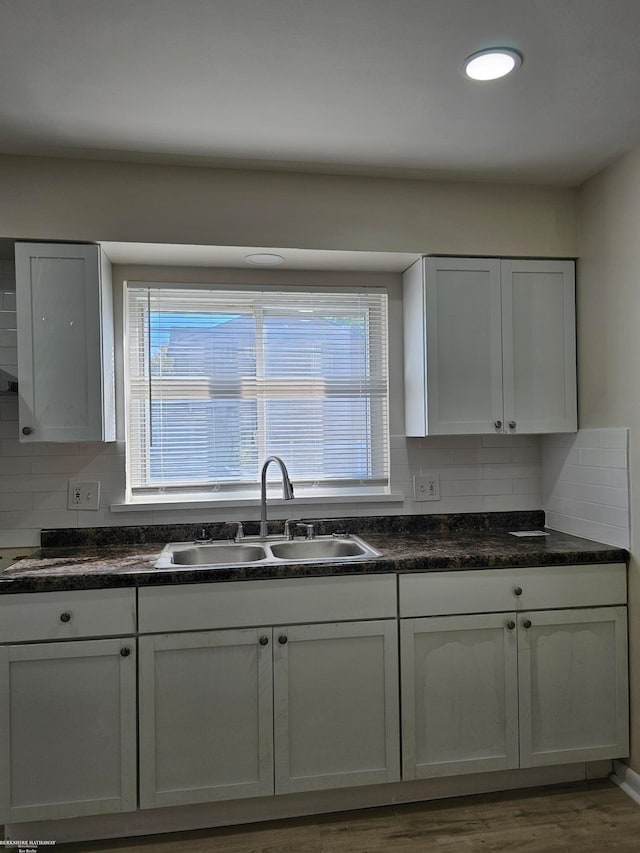 kitchen featuring white cabinets, hardwood / wood-style floors, sink, and tasteful backsplash