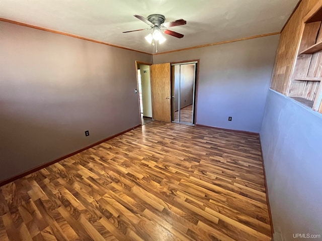 empty room with dark hardwood / wood-style flooring, ceiling fan, and crown molding