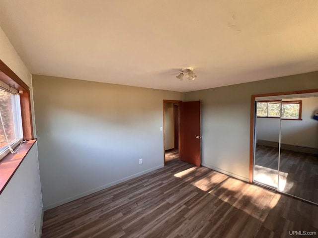 unfurnished bedroom featuring dark wood-type flooring and a closet