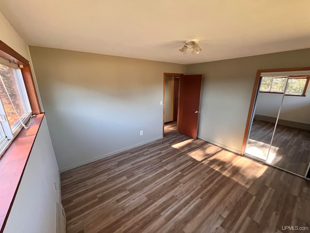 unfurnished bedroom with a closet and dark hardwood / wood-style floors