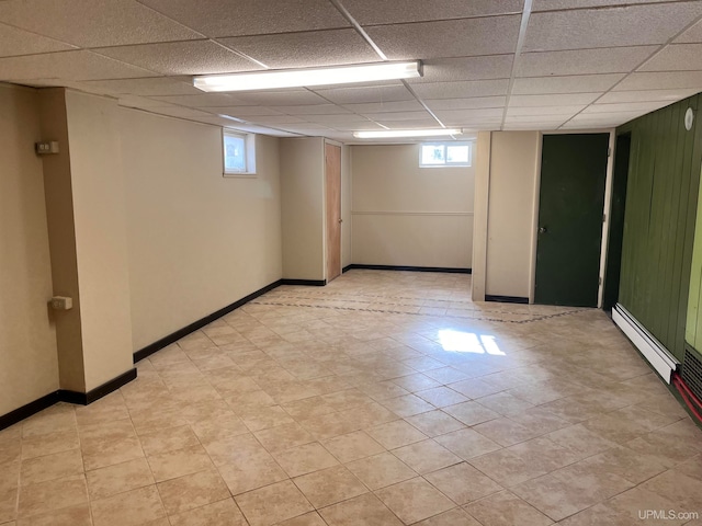 basement with a paneled ceiling and plenty of natural light