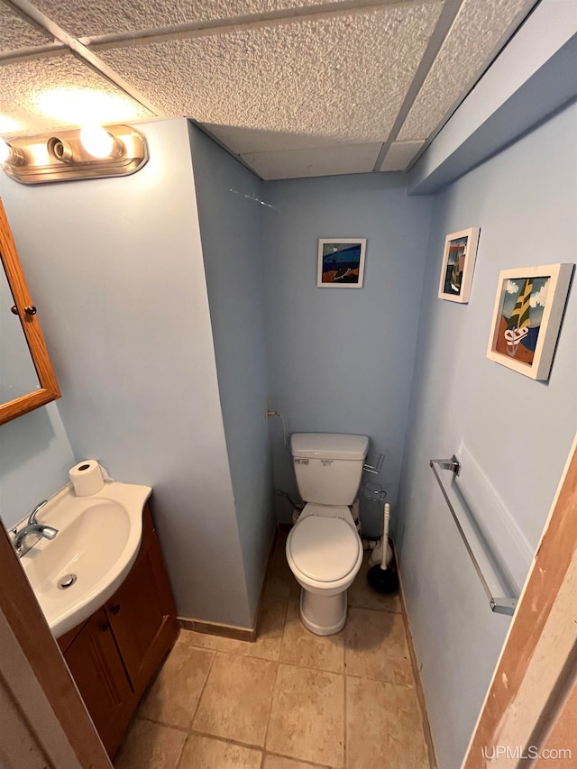 bathroom with toilet, vanity, and tile patterned floors