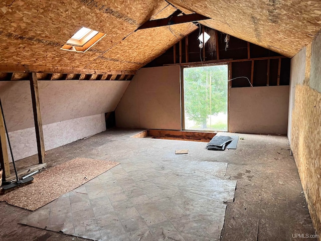 unfinished attic featuring a skylight