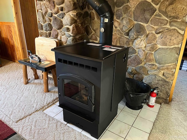 room details with wood walls, carpet, and a wood stove