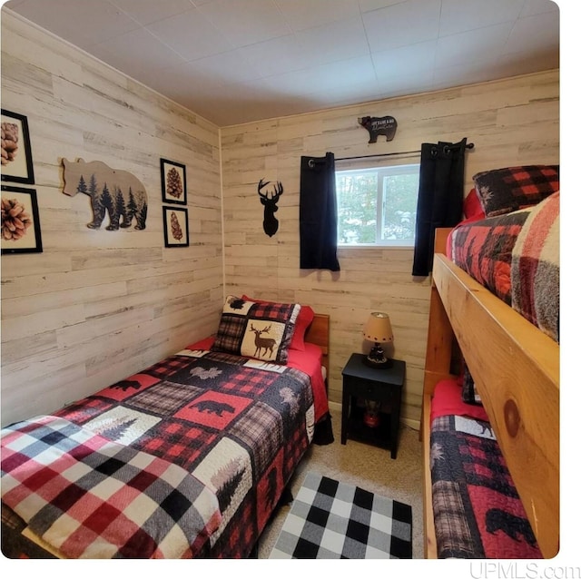 carpeted bedroom with wood walls