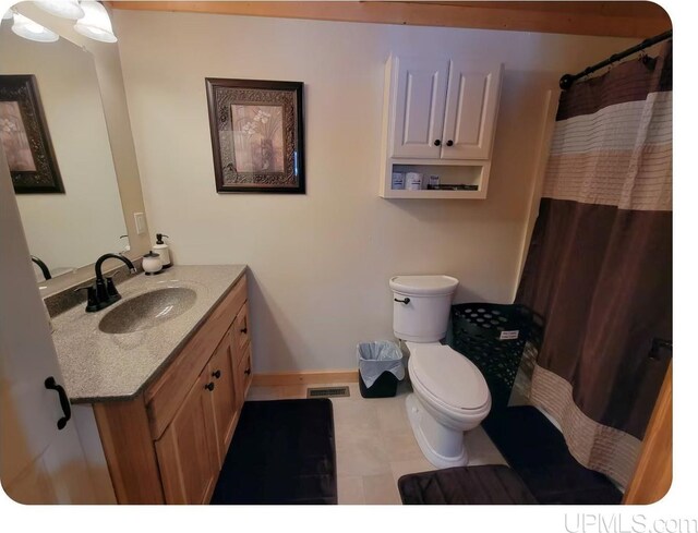 bathroom featuring tile patterned flooring, vanity, and toilet